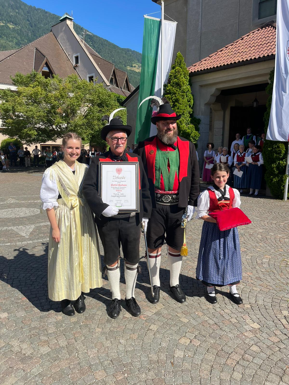 Melanie Mair, der geehrte Gottlieb Kaufmann, Hauptmann Christian Reiterer und Jungmarketenderin Tabea Reiterer bei der Übergabe der Ehrentafel
