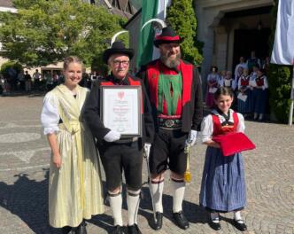 Melanie Mair, der geehrte Gottlieb Kaufmann, Hauptmann Christian Reiterer und Jungmarketenderin Tabea Reiterer bei der Übergabe der Ehrentafel